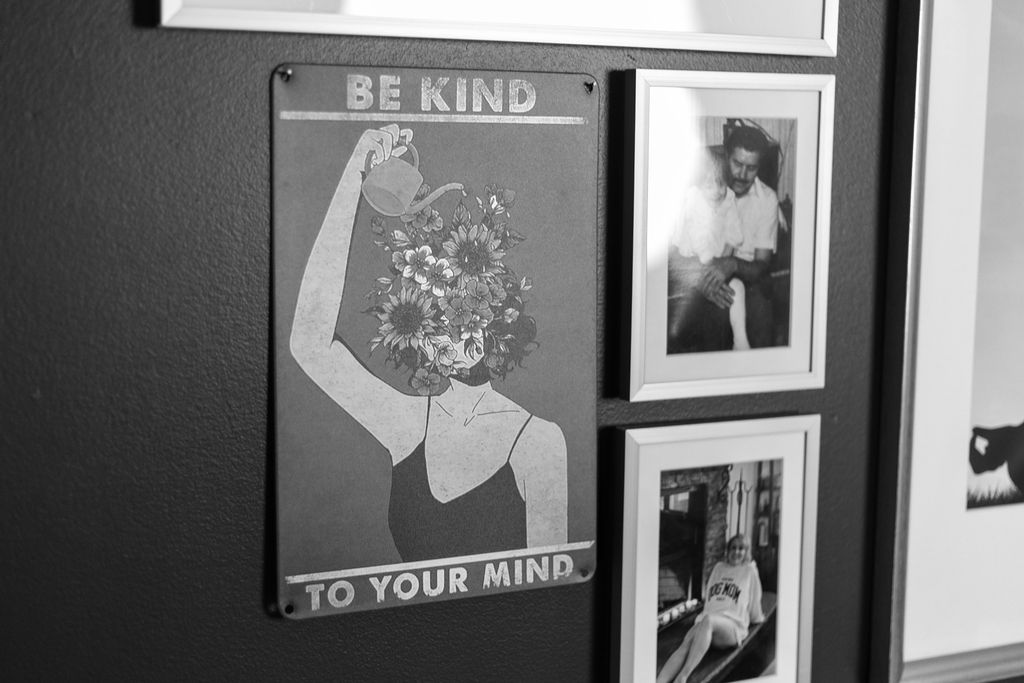 A Be Kind To Your Mind sign beside framed family photos